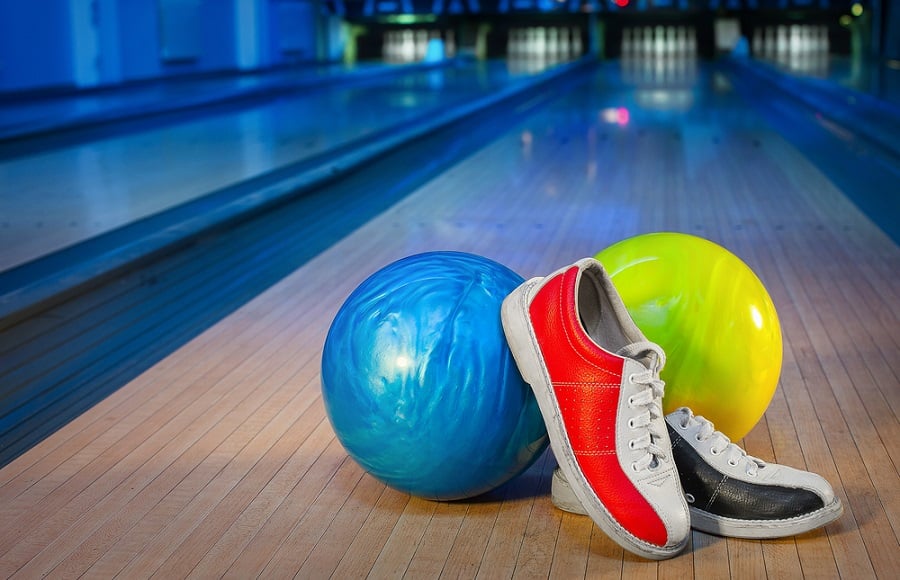 shoes and balls for bowling on the background of the playing field