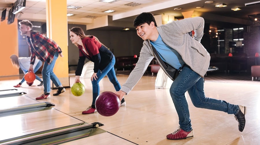 Friends playing bowling in club