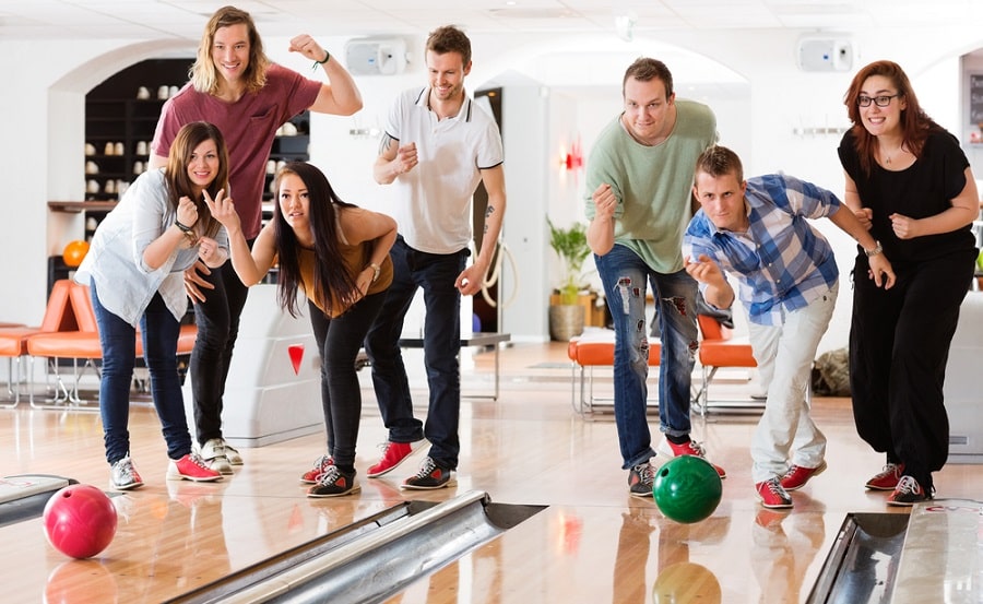 Young Friends Bowling While People Cheering